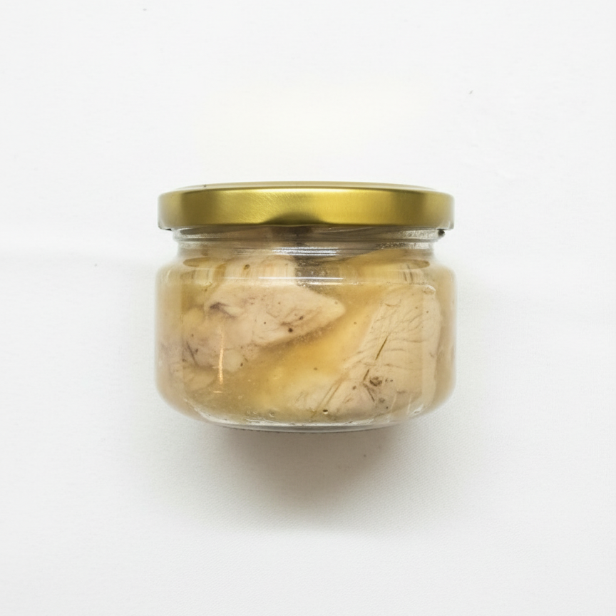Jar of pate with a gold lid on a white background